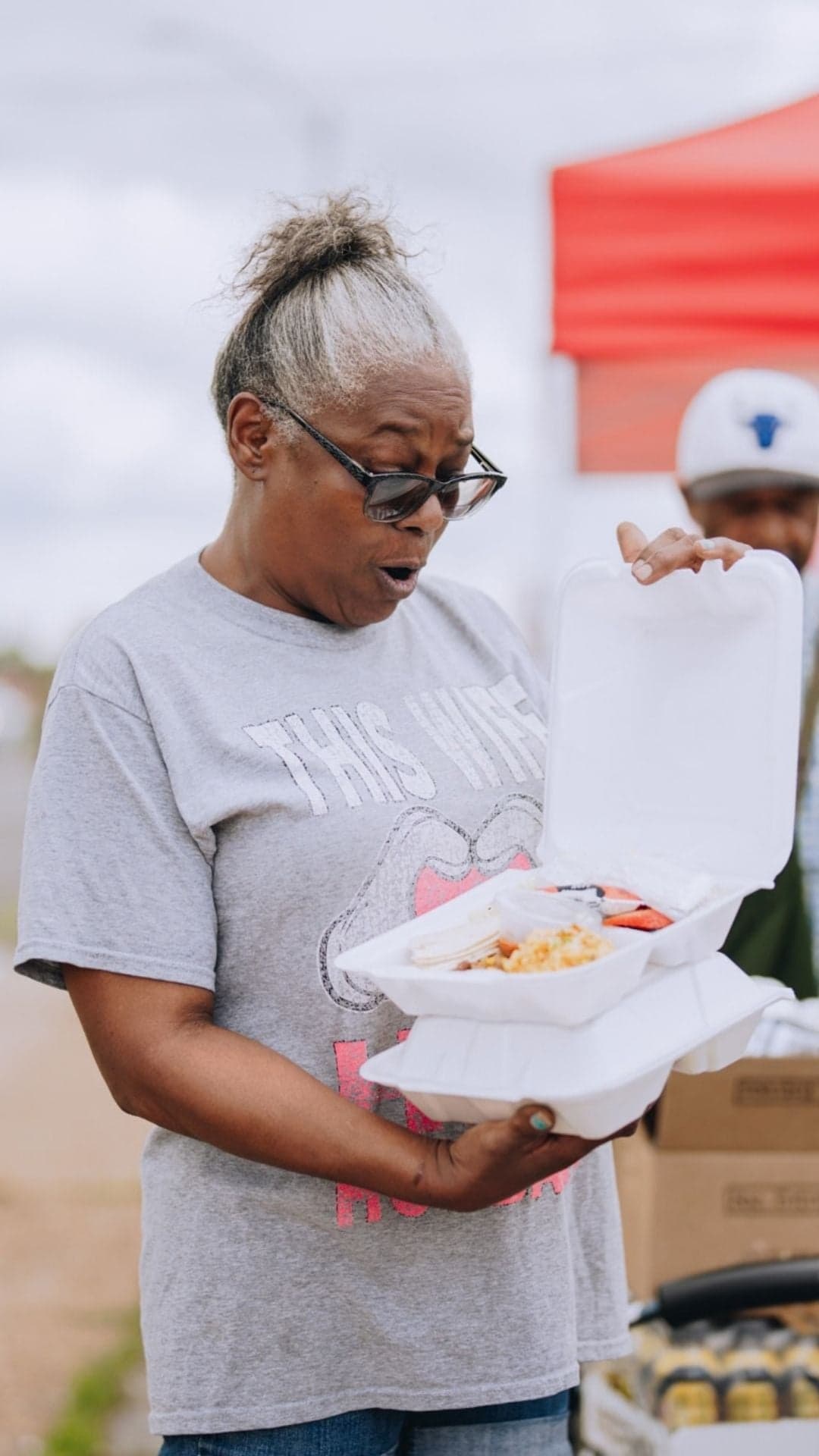 Woman is surprised to see a hot meal in a clamshell
