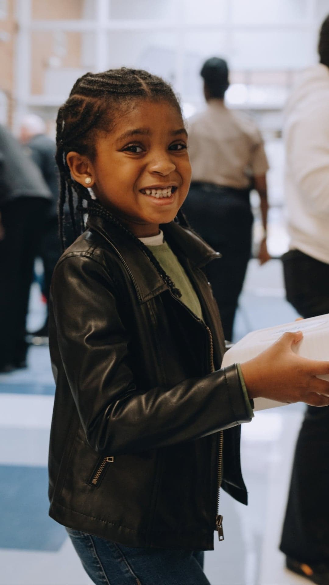 Young girl smiles as she receives a hot meal
