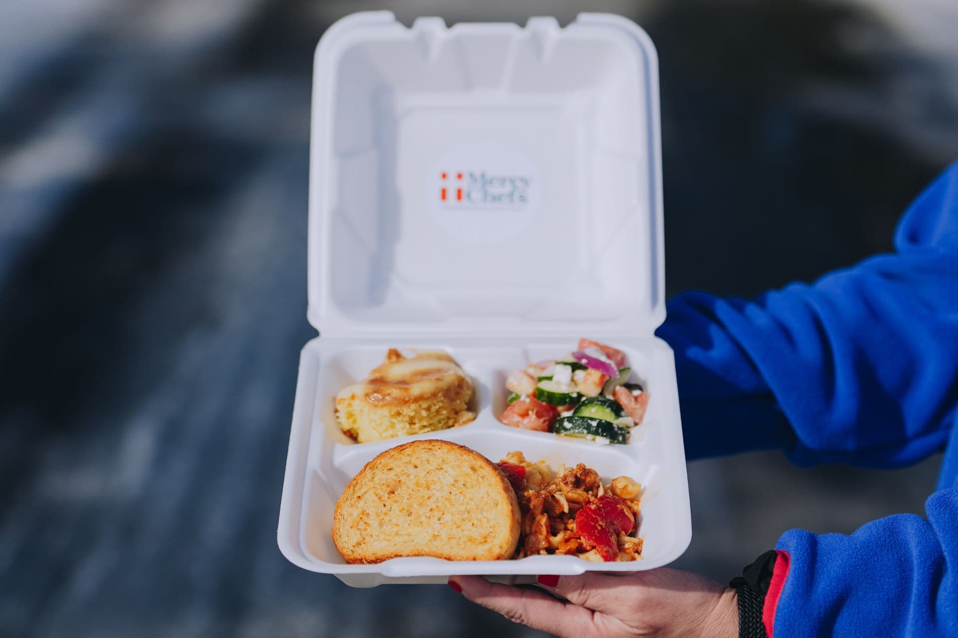 A warm plate of Italian chicken pasta with fresh salad and garlic bread, prepared by Mercy Chefs