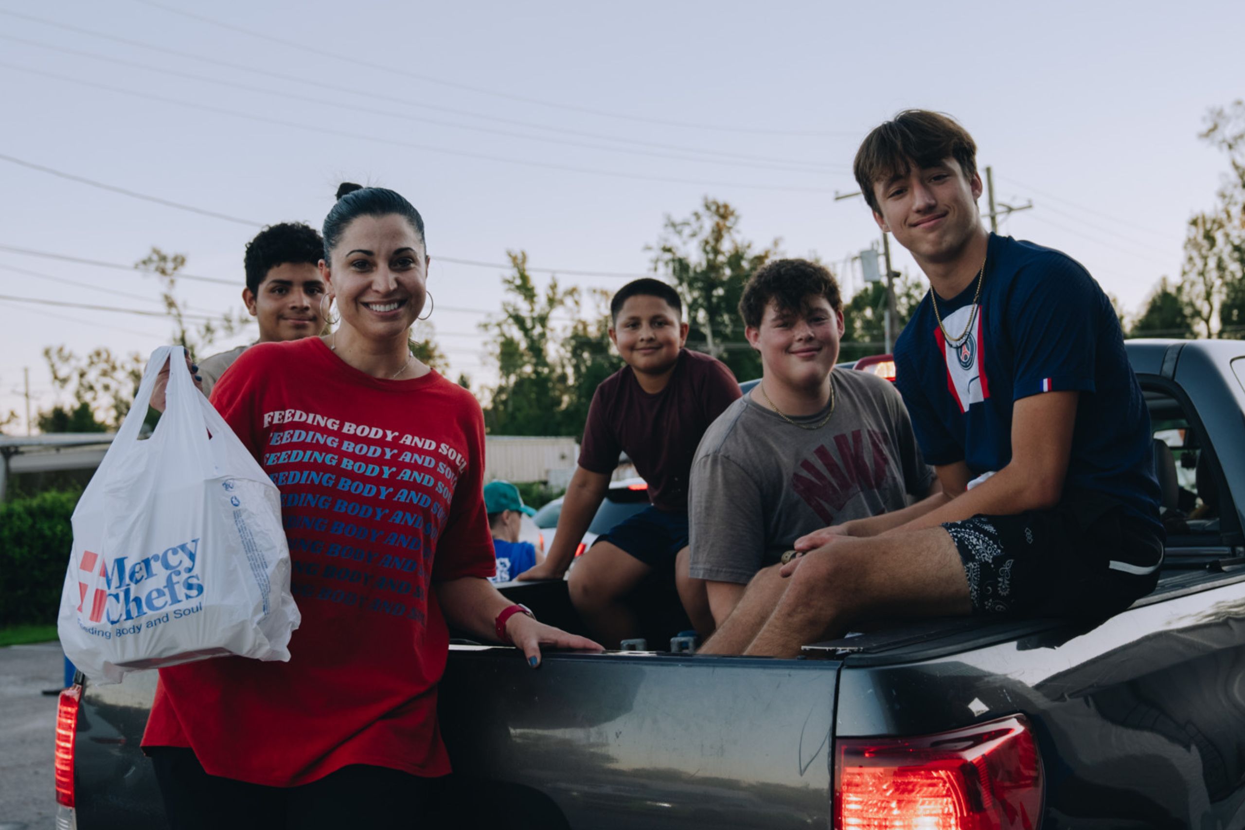 Mercy Chefs handing meals to a group of youth