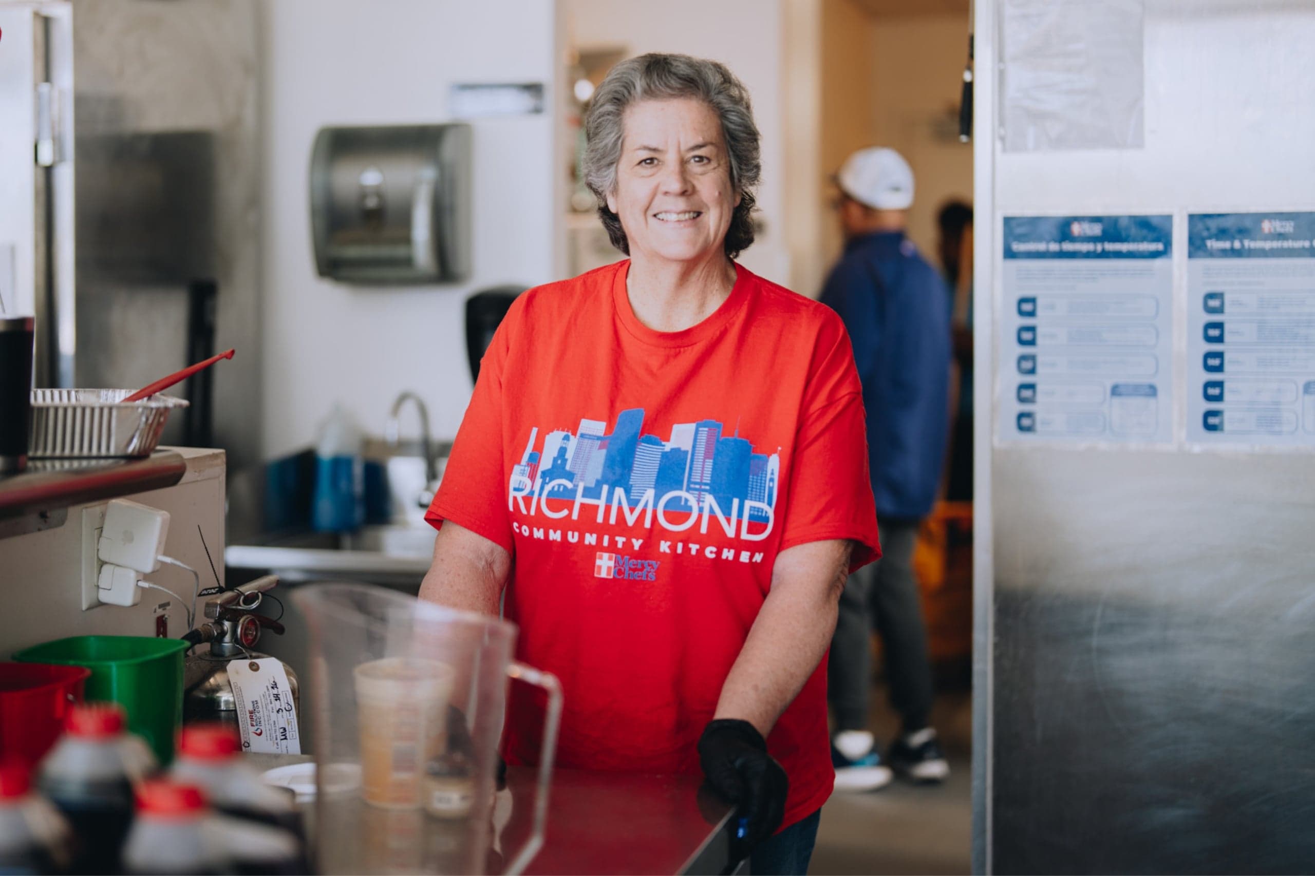 Richmond Community Kitchen volunteer smiles while preparing meals