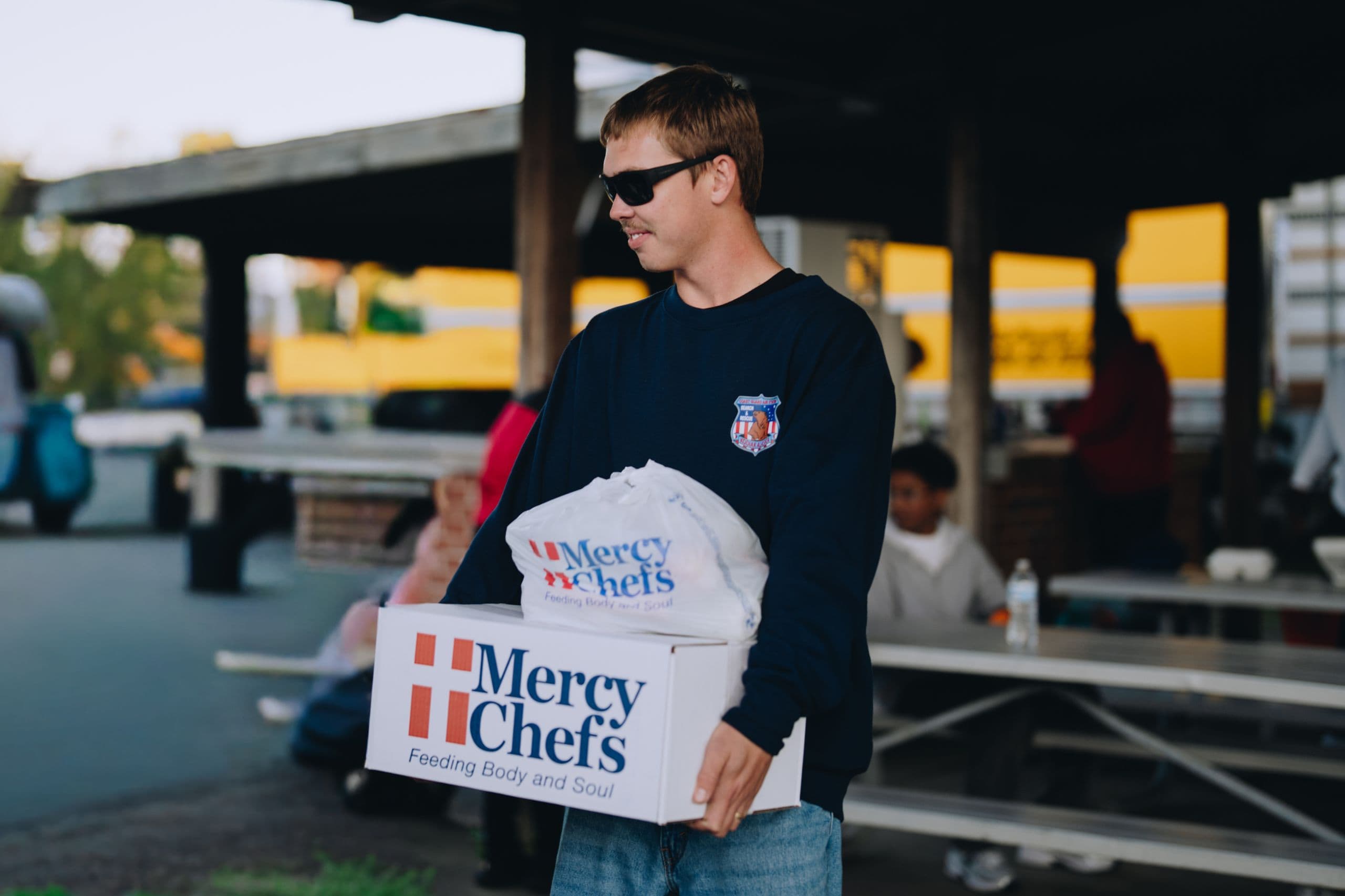 An enlisted service member receives Mercy Chefs' hot meals and groceries.